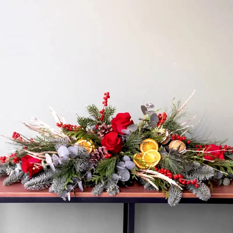 Centro de mesa navideño totalmente natural en tonos con rosas y verdes de temporada.